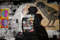 What We Here For back-print hoodie by Lines Of White — back view, worn by a man in a dark urban setting